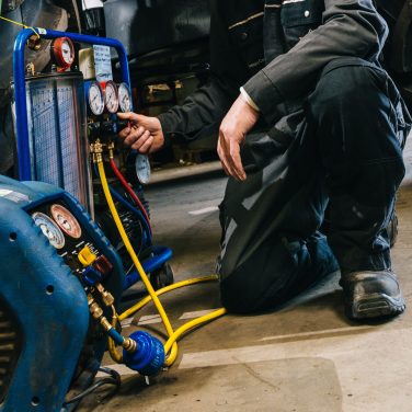 Mechanic servicing tractor air conditioning
